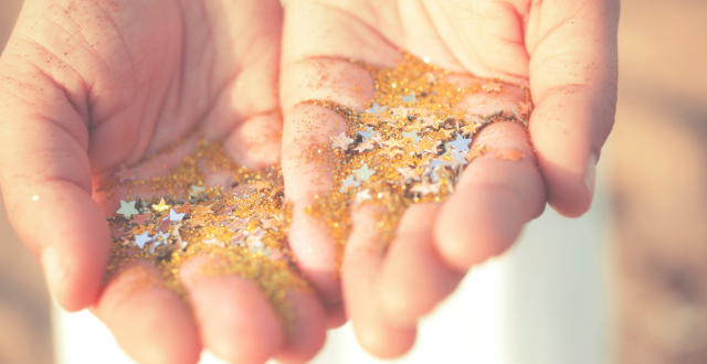 hands out holding gold glitter with stars