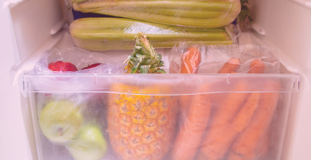 Crisper drawer in fridge full of fruits and vegetables