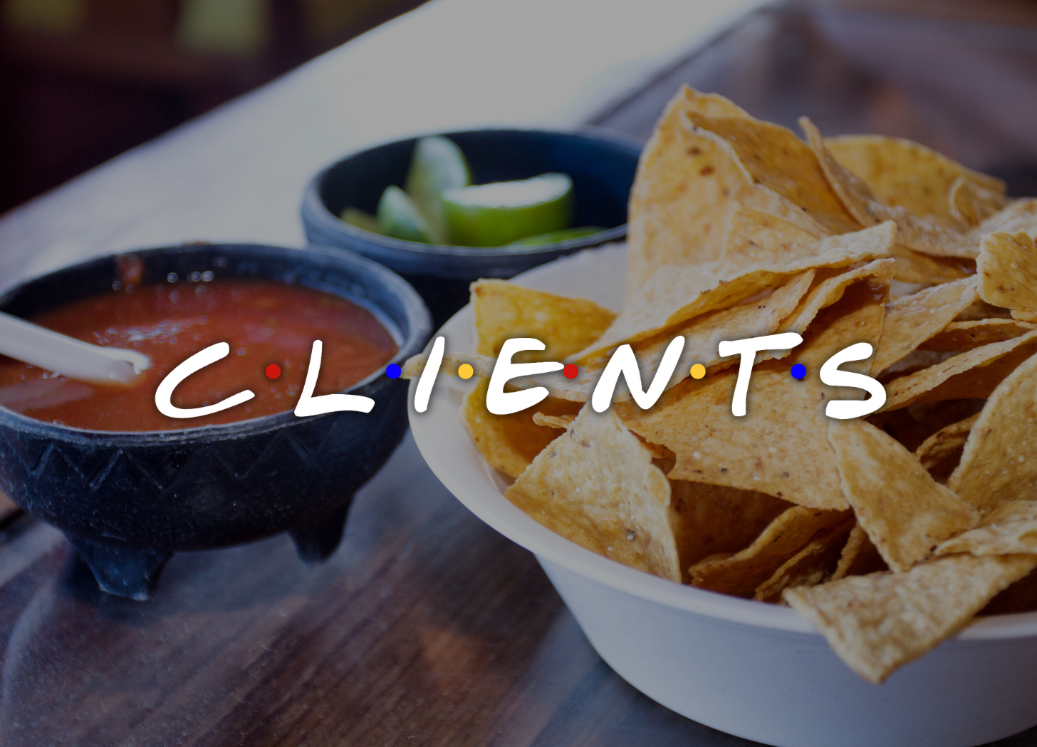 Bowl of chips and salsa and a small bowl of limes with the word CLIENTS written overtop in the same font style as the sitcom Friends.