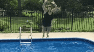 Deanna Seymour jumping into the pool with grass and trees behind her in a gif